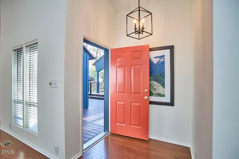 an empty room with wooden floor closet and windows