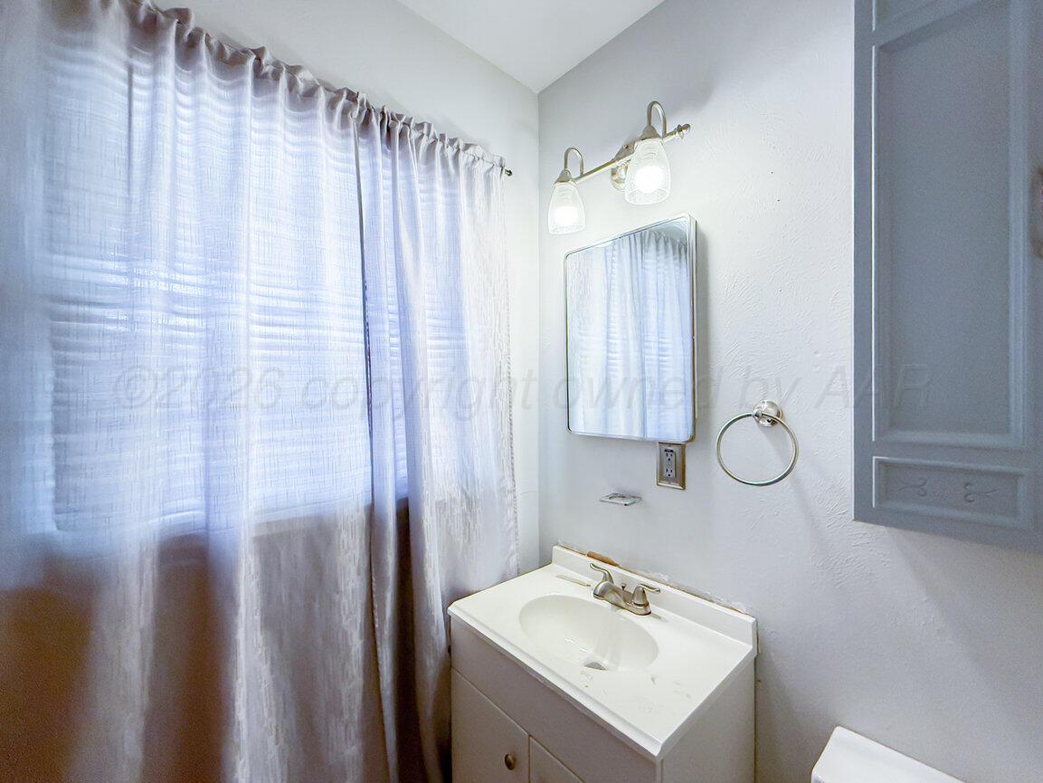 4305 South Bonham Street Amarillo, TX 79110 - Photo 39 of 48 a bathroom with a sink a mirror and a shower curtain