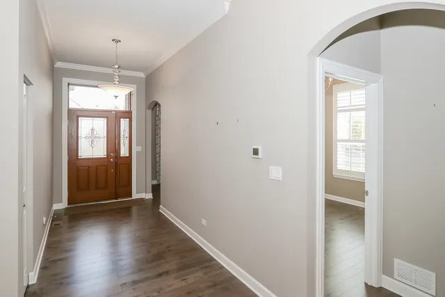 a view of a hallway with wooden floor and a window