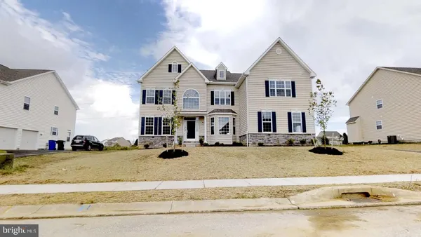 a view of a big house with cars in front of it