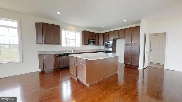 a kitchen with stainless steel appliances granite countertop a white cabinets and a refrigerator