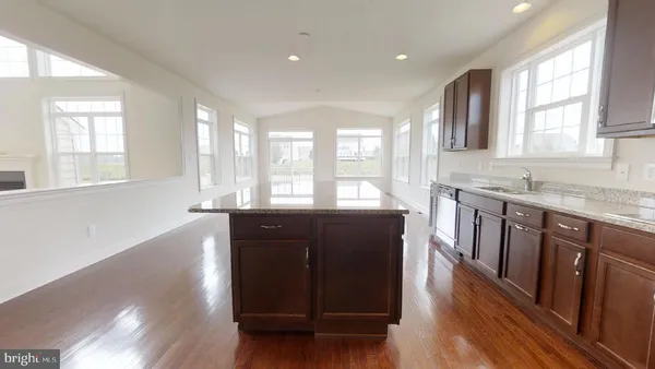 a kitchen with a sink a window and wooden floor