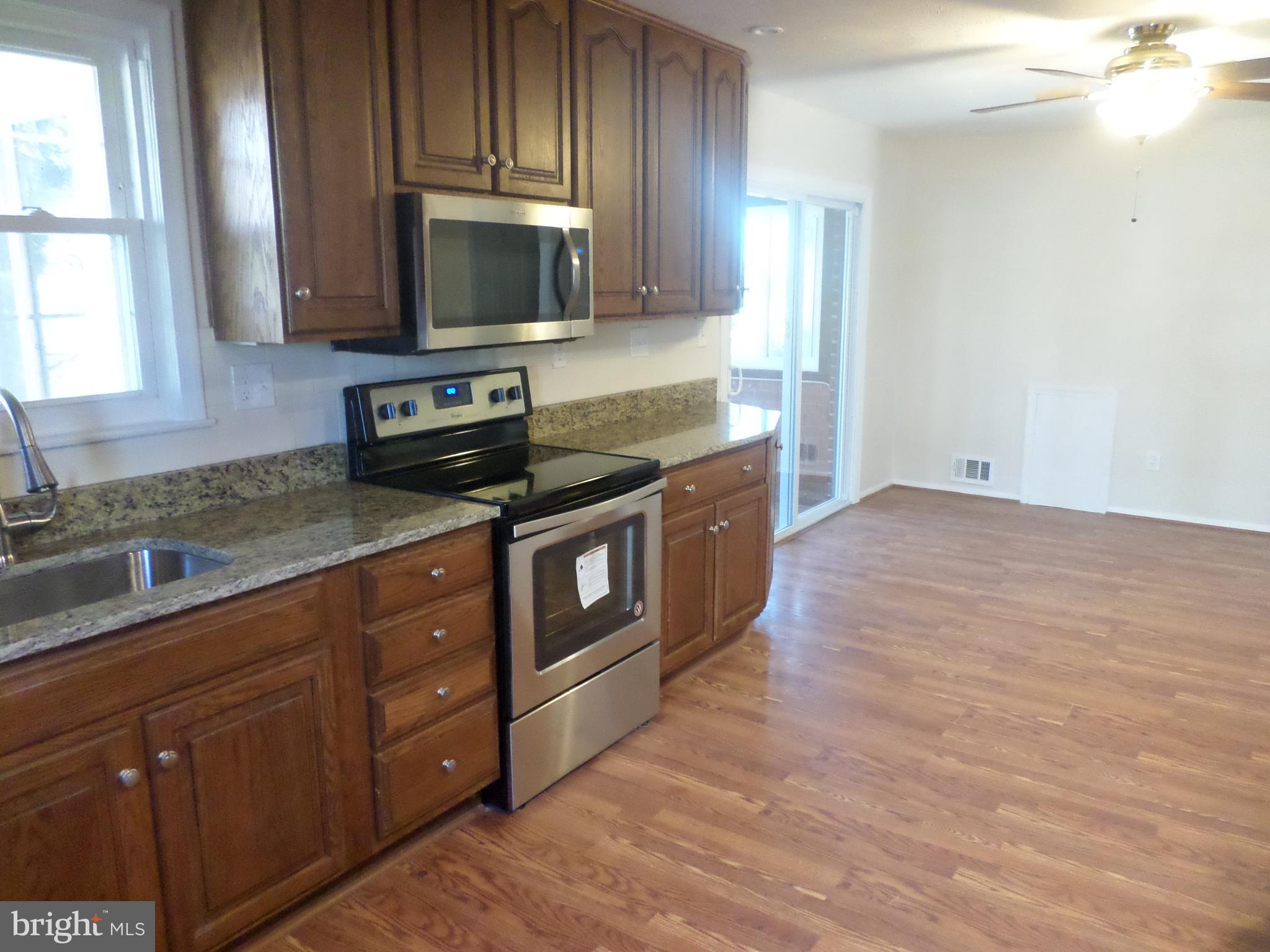 2976 Gracefield Road Silver Spring, MD 20904 - Photo 5 of 25 a kitchen with stainless steel appliances granite countertop a stove a sink and a microwave