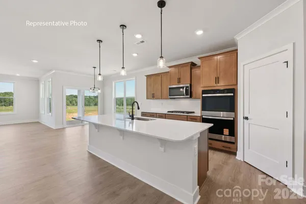 a large kitchen with stainless steel appliances a large counter top