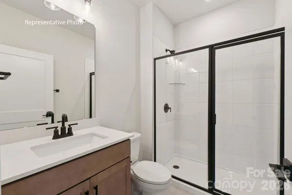 a bathroom with a sink toilet a mirror and shower