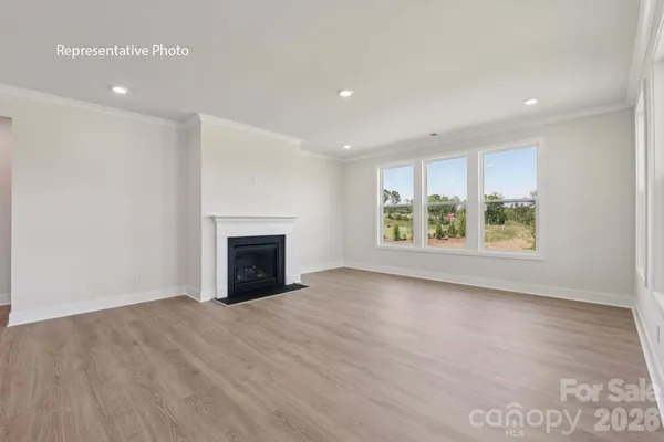 an empty room with windows and fireplace