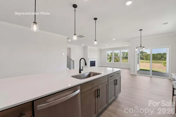 a kitchen with stainless steel appliances granite countertop a sink a window and wooden floor