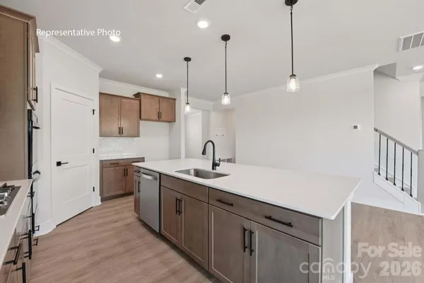 a kitchen with a sink a counter space appliances and cabinets