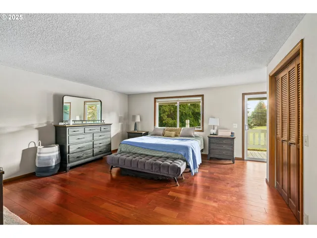 a bed sitting in a spacious bedroom next to a window