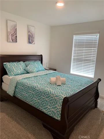 a bed sitting in a bedroom next to a window