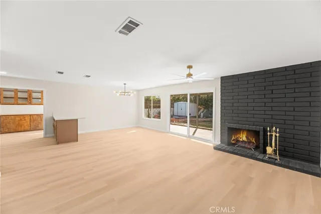 a view of an empty room with a fireplace and a window