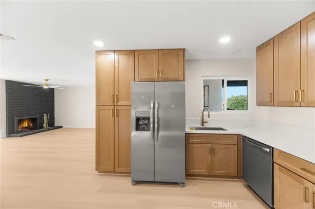 a kitchen with stainless steel appliances granite countertop a refrigerator a sink and a stove