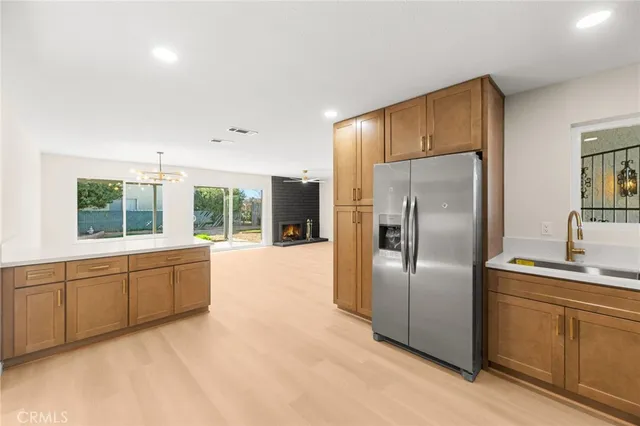 a large kitchen with stainless steel appliances granite countertop a refrigerator and a sink