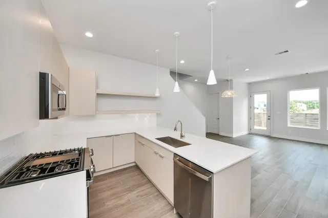 a kitchen with a sink a stove and cabinets