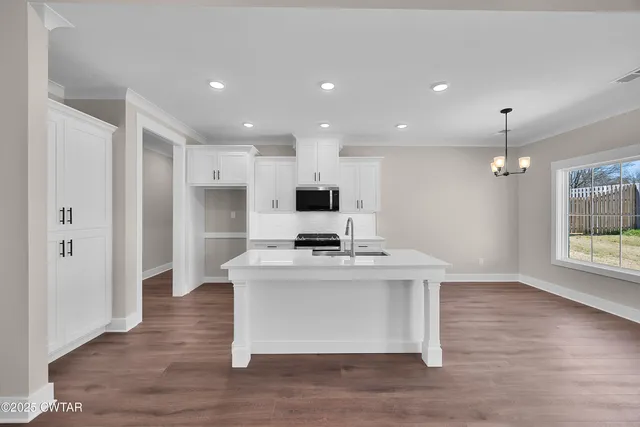 a view of a kitchen with cabinets and wooden floor