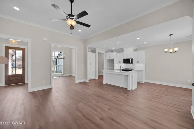 a view of kitchen with cabinets appliances and a ceiling fan