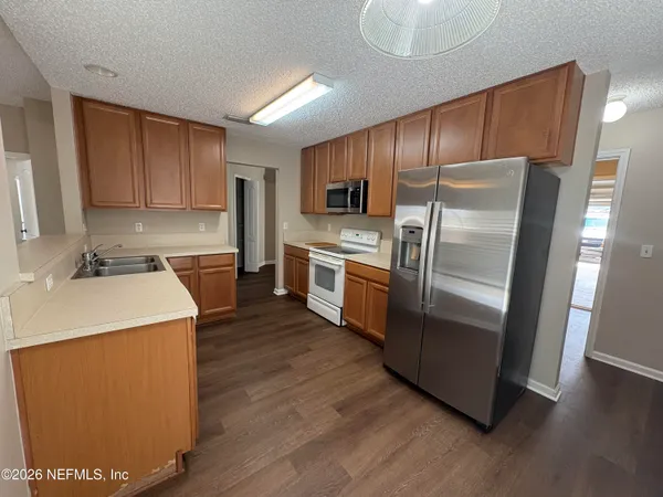 a kitchen with stainless steel appliances granite countertop a refrigerator a sink a stove a microwave and island