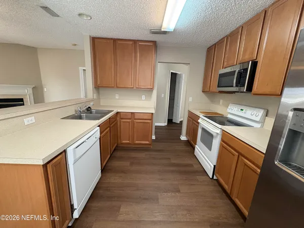 a kitchen with sink a microwave a stove and refrigerator