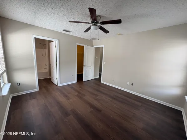a view of a room with wooden floor and a ceiling fan