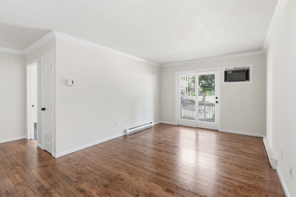 30 Abbey Road, Unit 102 Leominster, MA 01453 - Photo 4 of 15 an empty room with wooden floor and windows
