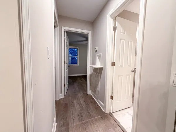 a view of a hallway with wooden floor