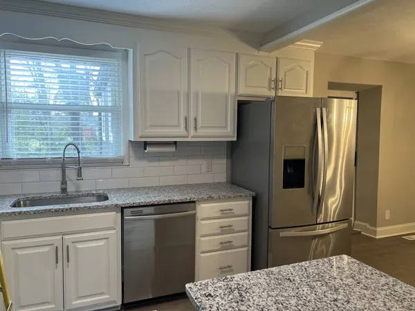 a kitchen with a refrigerator sink and cabinets