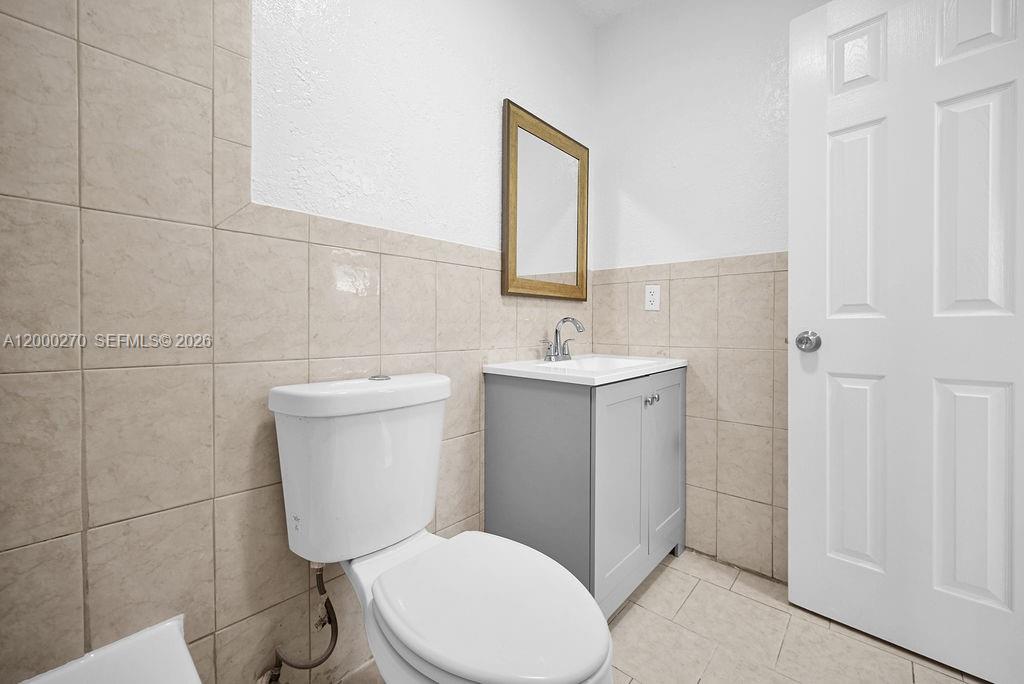 6951 Southwest 7th Street Margate, FL 33068 - Photo 14 of 45 a white toilet sitting next to a bathroom sink