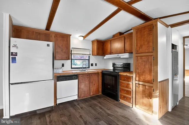 a kitchen with granite countertop stainless steel appliances a refrigerator a sink and a cabinets