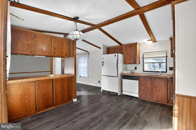 a kitchen view with wooden floor and electronic appliances