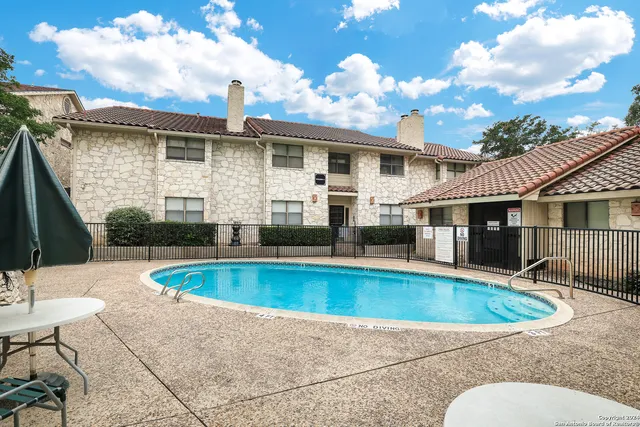a view of a house with swimming pool and sitting area