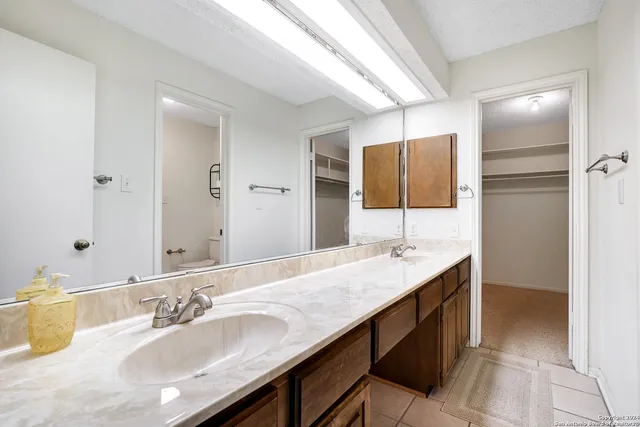 a bathroom with a granite countertop sink and a mirror