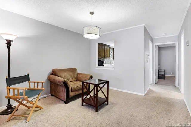 a living room with furniture a chandelier and a window