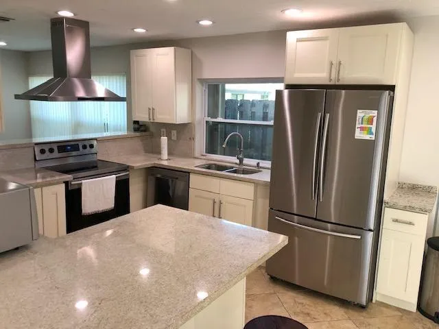 a kitchen with stainless steel appliances a sink a stove a refrigerator and cabinets