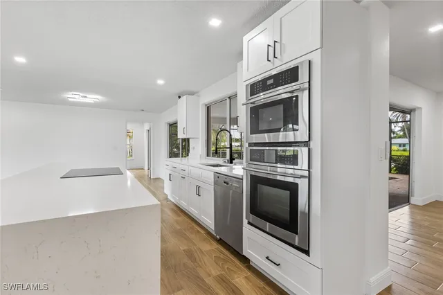 a kitchen with stainless steel appliances a stove microwave and sink
