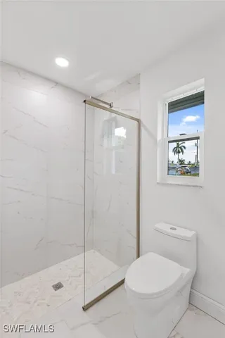 a bathroom with a toilet and a shower