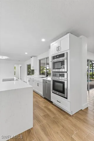 a kitchen with stainless steel appliances a stove top oven and cabinets