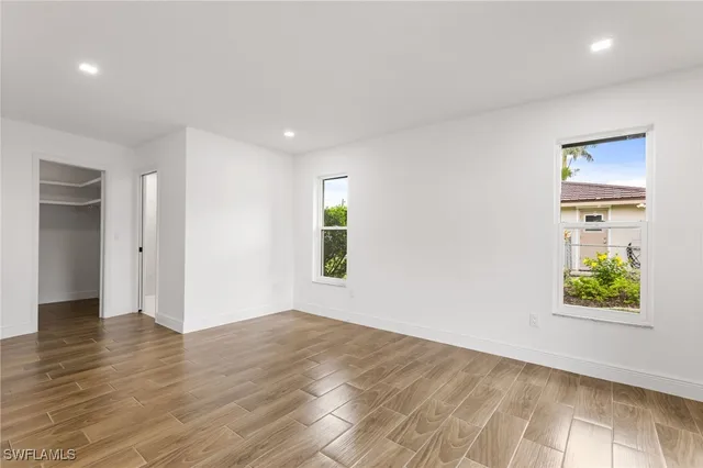 an empty room with windows and closet