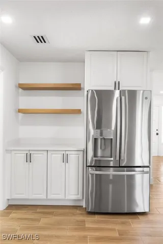 a metallic refrigerator freezer sitting in a kitchen