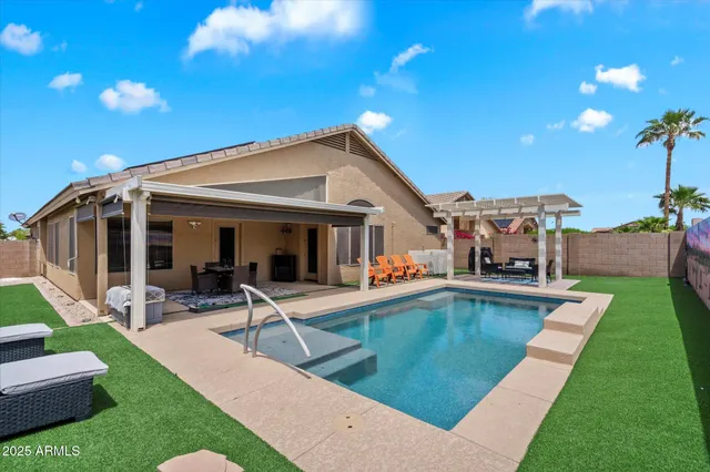 a view of a house with swimming pool and sitting area