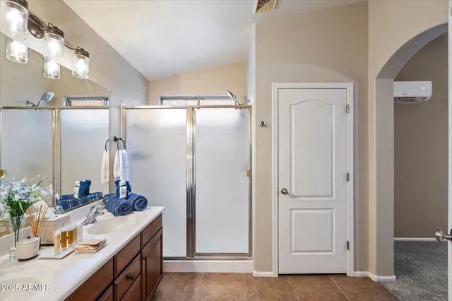a bathroom with a granite countertop sink a mirror and shower