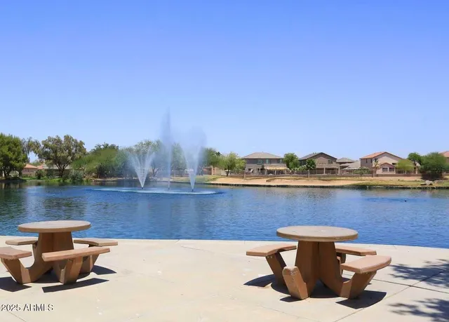 a view of a lake with a table and chairs