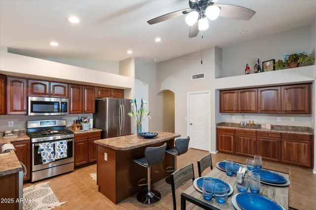 a kitchen with stainless steel appliances kitchen island granite countertop a sink and cabinets