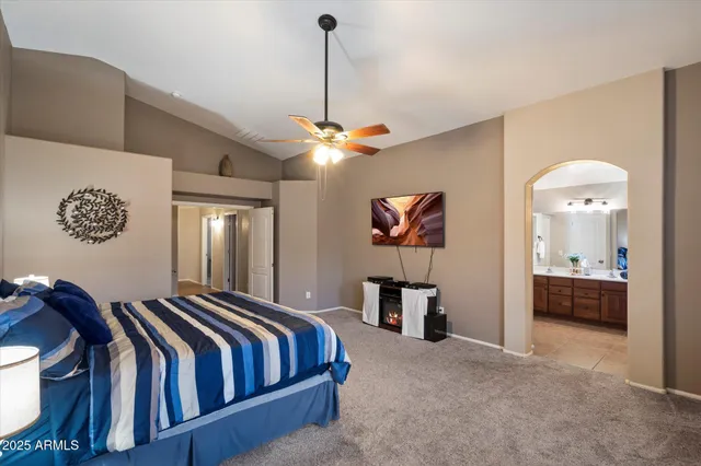 a spacious bedroom with a bed and a chandelier