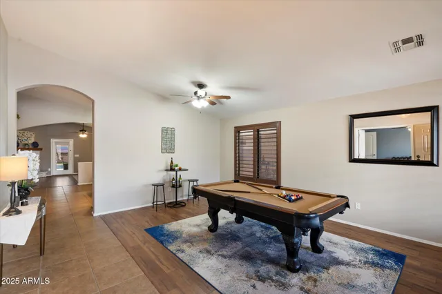 a room with furniture pool table and wooden floor