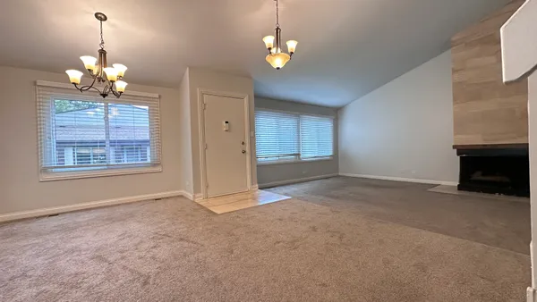 a view of livingroom with chandelier fan and kitchen view