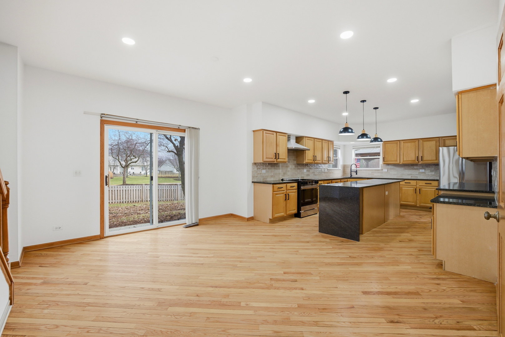 2812 Stuart Kaplan Court Aurora, IL 60503 - Photo 9 of 34 a kitchen with stainless steel appliances kitchen island granite countertop a stove top oven a sink dishwasher a dining table and chairs with wooden floor