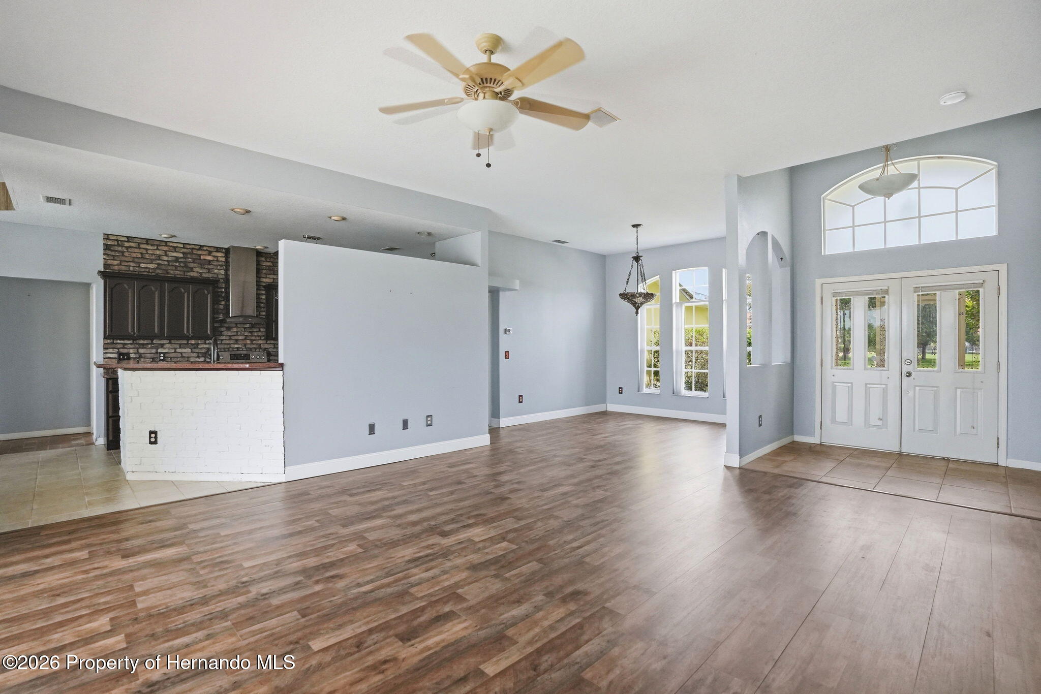 18131 Rivard Boulevard Brooksville, FL 34604 - Photo 11 of 66 wooden floor in an empty room with a window