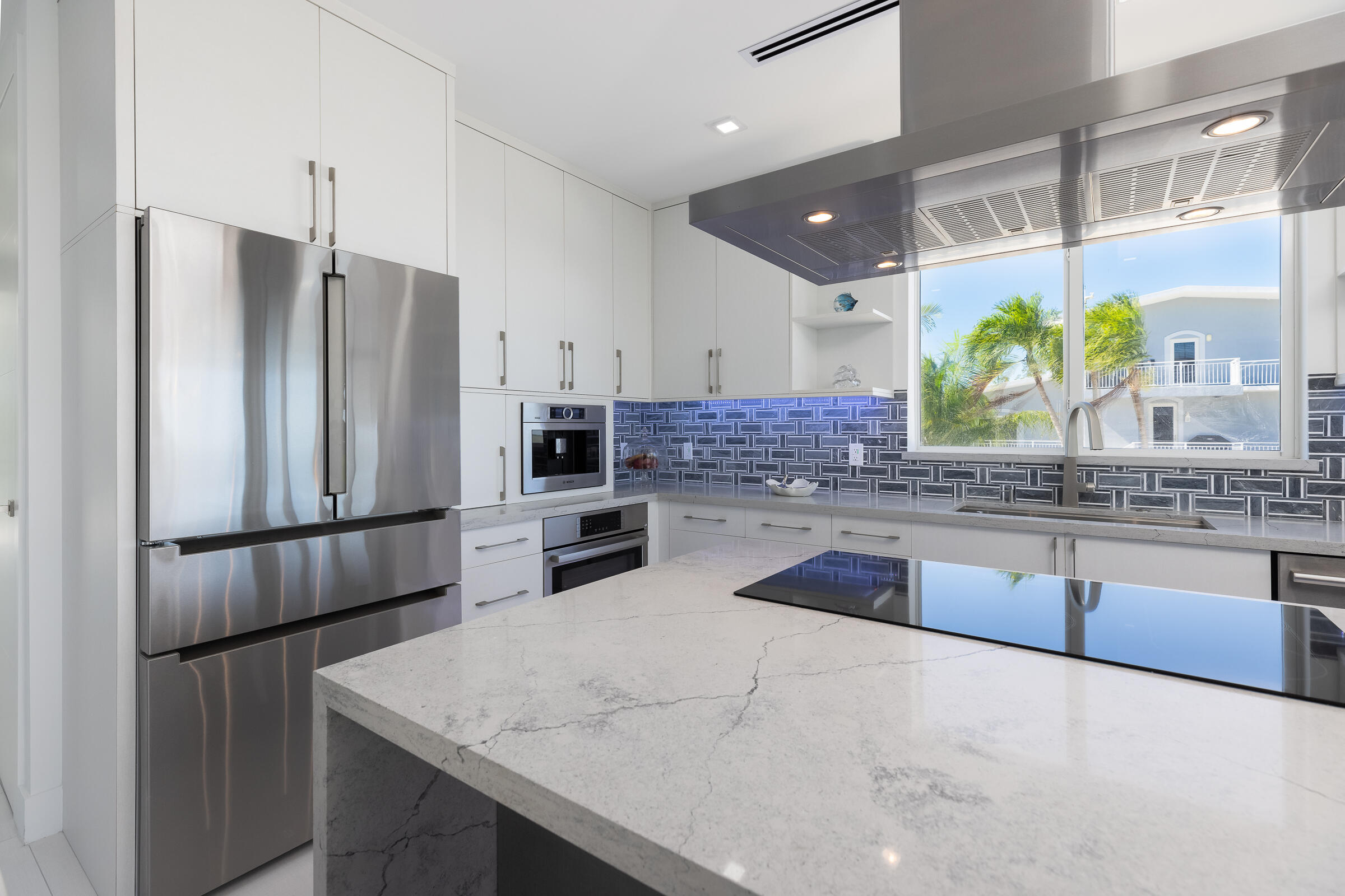 45 Cormorant Drive Key Largo, FL 33037 - Photo 12 of 51 a kitchen with stainless steel appliances a sink refrigerator and microwave