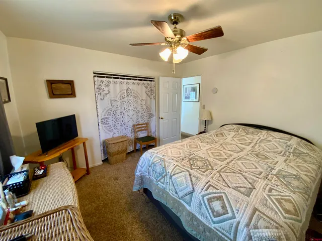 a bedroom with a bed a chandelier and a flat screen tv