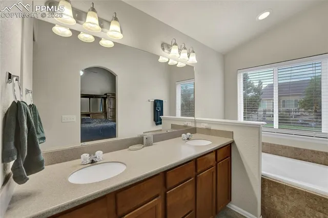a bathroom with a granite countertop sink a large mirror and a window